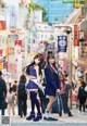 A couple of girls standing next to each other on a city street.