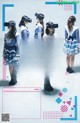 A group of girls wearing vr headsets standing in front of a poster.