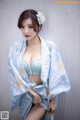 A woman in a blue and white kimono posing for a picture.