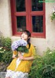 A woman sitting on a bench holding a bunch of flowers.