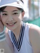 A young woman wearing a white tennis outfit and a white hat.