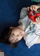 A young girl laying on the floor playing a video game.